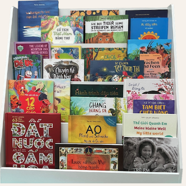 Vietnamese children's books arranged on a white shelf